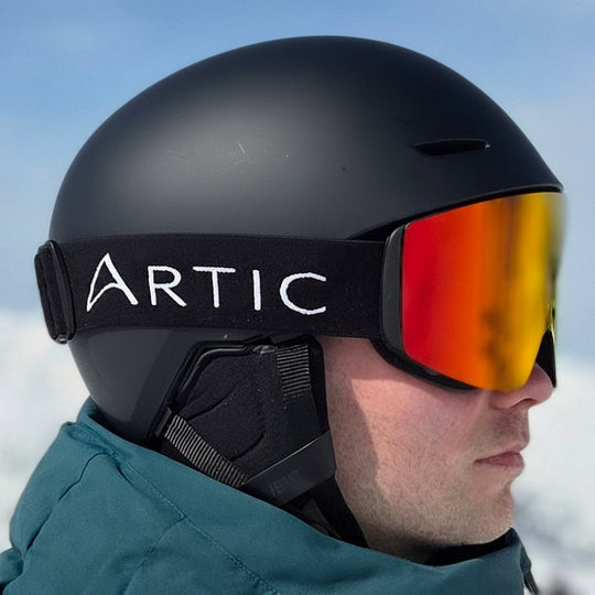 Skibril met oranje meekleurende lens op man en helm