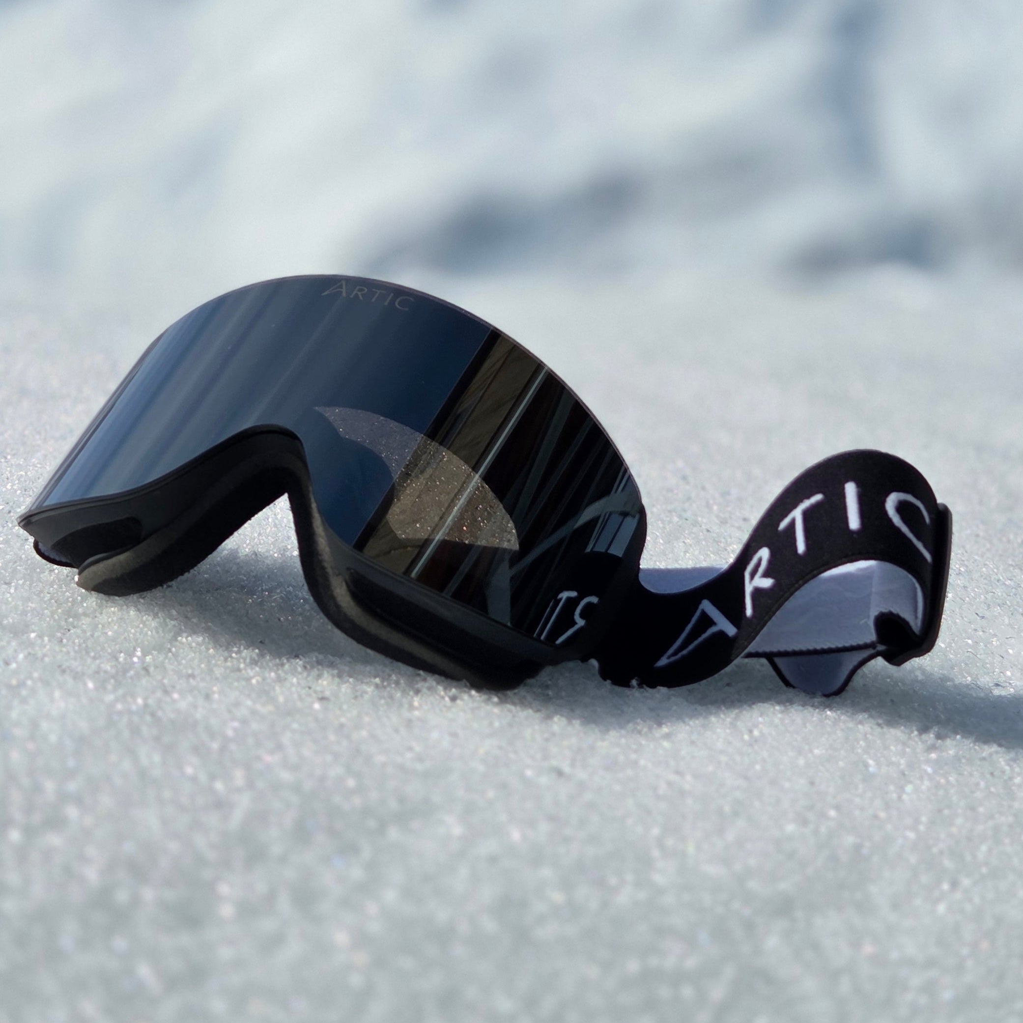Skibril met zwarte afneembare lens in de sneeuw