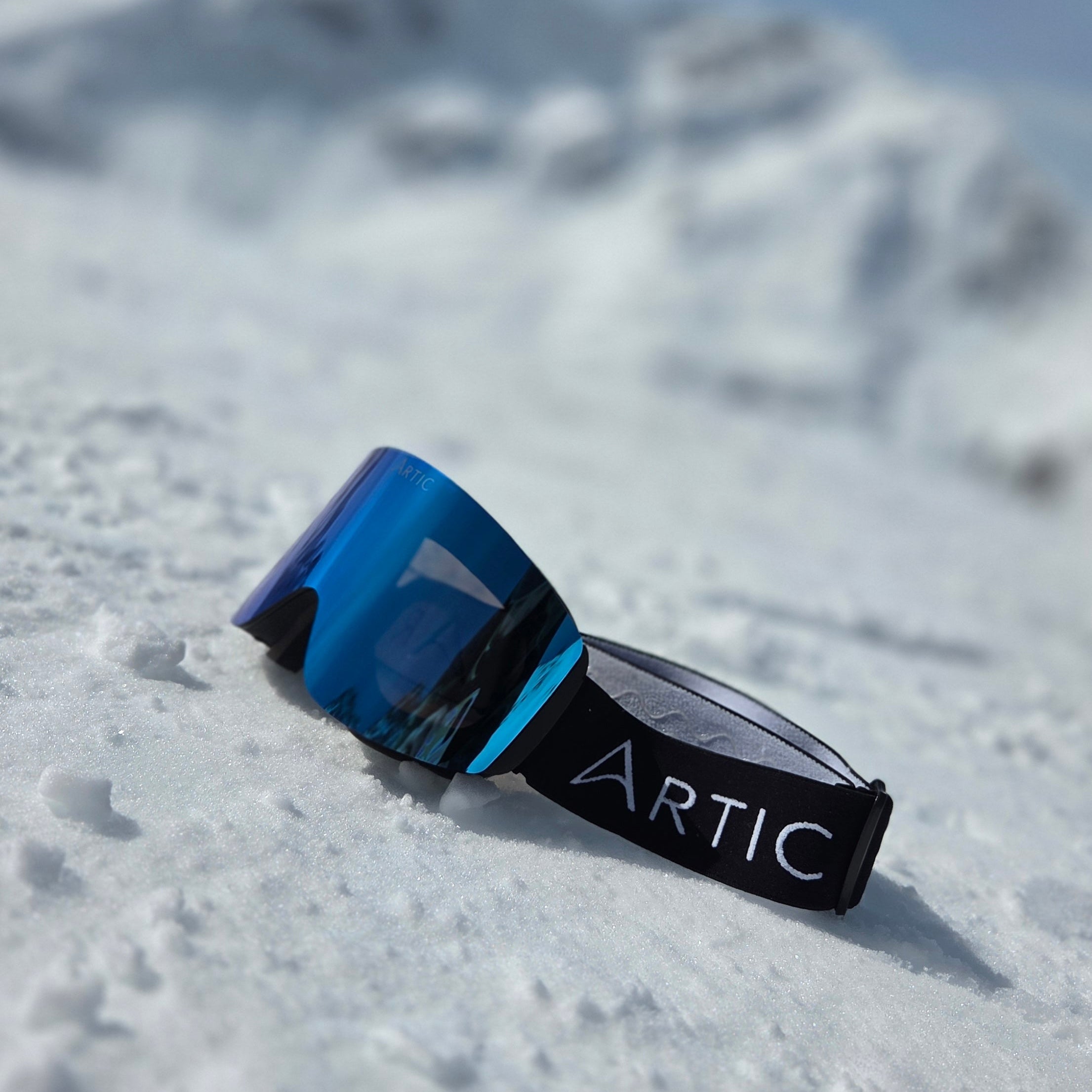 Skibril met blauwe afneembare lens in de sneeuw